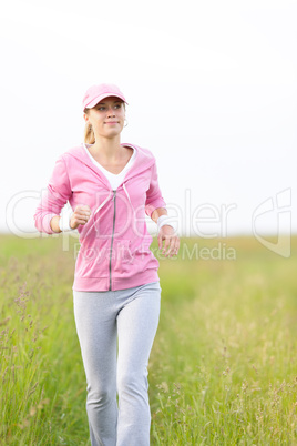 Jogging sportive young woman running park field