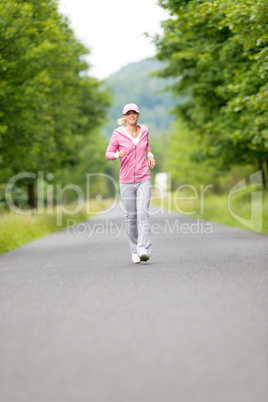 Jogging sportive young woman running park road