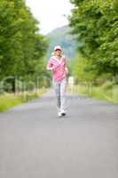 Jogging sportive young woman running park road