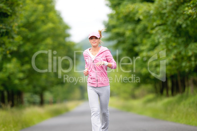 Jogging sportive young woman running park road