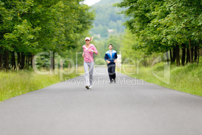 Jogging sportive young couple running park road