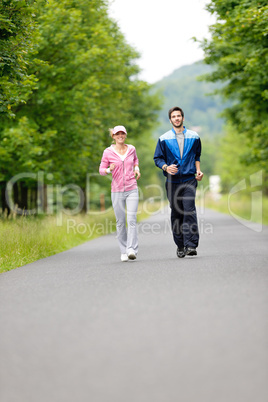 Jogging sportive young couple running park road