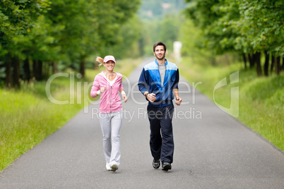 Jogging sportive young couple running park road