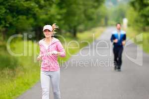 Jogging sportive young couple running park road