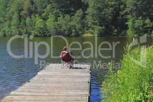 Elderly woman fishing from the dock.