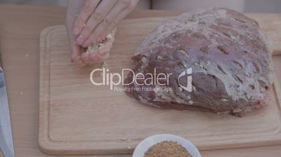 Rubbing fat piece of pork with finely chopped garlic