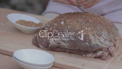 Rubbing piece of pork with crumbled bay leaves