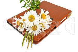 Notebook with pen and daisies