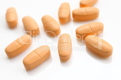 orange pills over white