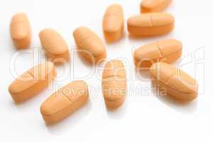 orange pills over white
