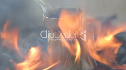 Close-up of bronze coffee maker standing on fire