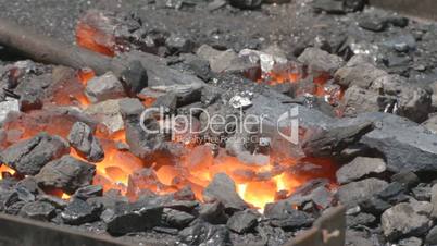 Covering glowing embers with coal