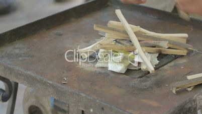 Making fire on forge table with paper and wood