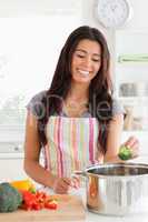 Good looking woman preparing vegetables while standing