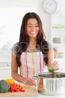 Pretty woman preparing vegetables while standing