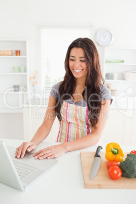 Good looking woman relaxing with her laptop while standing