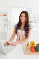 Charming woman relaxing with her laptop while standing