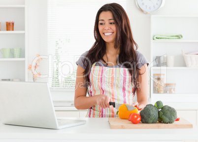 Good looking woman relaxing with her laptop while standing