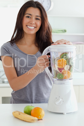 Good looking woman using a blender while standing
