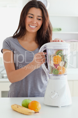 Beautiful woman using a blender while standing