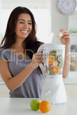 Gorgeous woman using a blender while standing