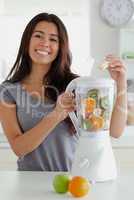 Lovely woman using a blender while standing
