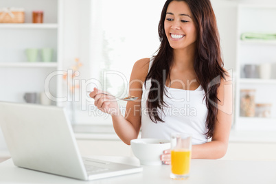 Pretty woman enjoying a bowl of cereals while relaxing with her