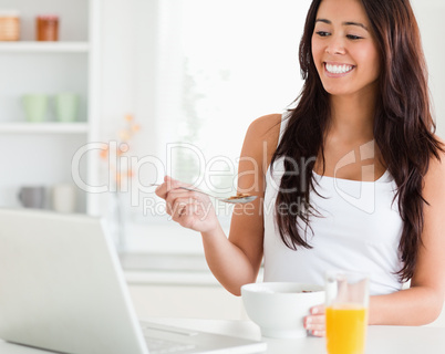Beautiful woman enjoying a bowl of cereals while relaxing with h