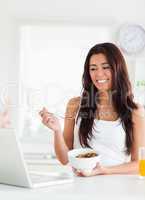 Good looking woman enjoying a bowl of cereals while relaxing wit