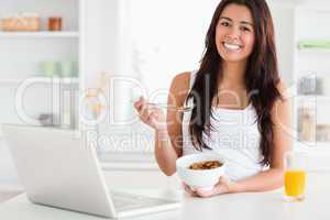 Attractive woman enjoying a bowl of cereals while relaxing with