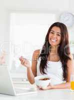 Gorgeous woman enjoying a bowl of cereals while relaxing with he
