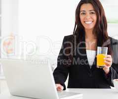 Beautiful woman in suit relaxing with her laptop while holding a