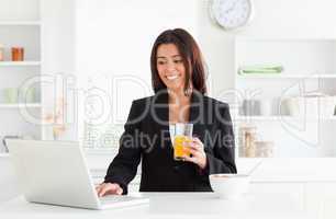Charming woman in suit relaxing with her laptop while holding a