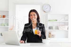 Gorgeous woman in suit relaxing with her laptop while holding a