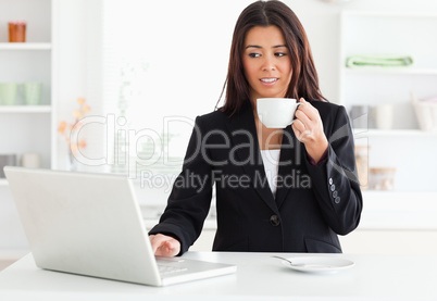 Gorgeous woman in suit enjoying a cup of coffee while relaxing w