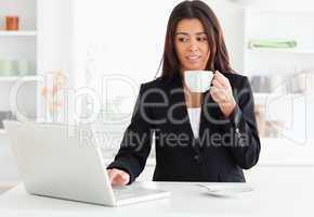 Gorgeous woman in suit enjoying a cup of coffee while relaxing w