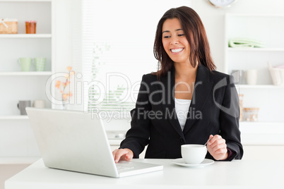 Beautiful woman in suit enjoying a cup of coffee while relaxing