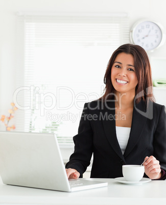 Good looking woman in suit enjoying a cup of coffee while relaxi