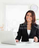 Good looking woman in suit enjoying a cup of coffee while relaxi