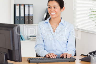 Beautiful woman typing on a keyboard while sitting