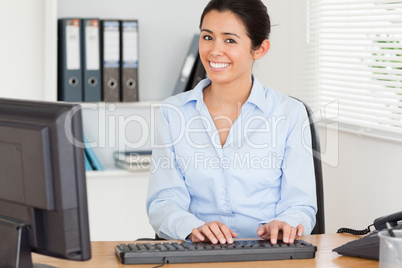 Attractive woman typing on a keyboard while sitting