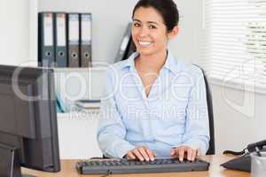 Attractive woman typing on a keyboard while sitting