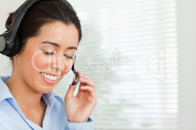 Portrait of a lovely woman with a headset helping customers whil