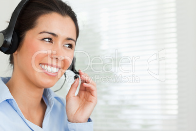 Portrait of a pretty woman with a headset helping customers whil