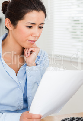 Attractive woman looking holding a sheet of paper
