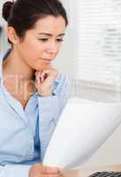 Attractive woman looking holding a sheet of paper