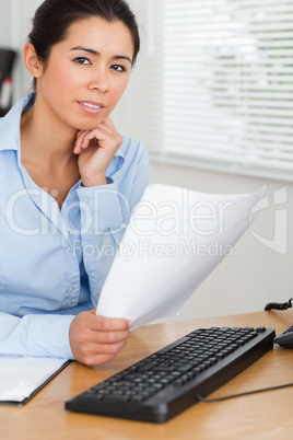 Attractive woman posing while holding a sheet of paper