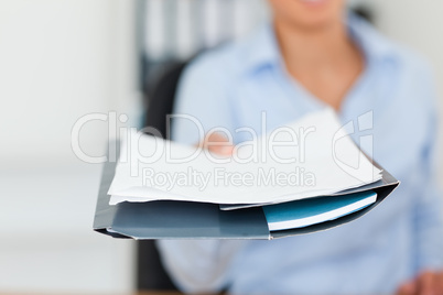 Beautiful woman showing a sheet of paper to the camera