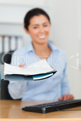 Attractive woman showing a sheet of paper to the camera