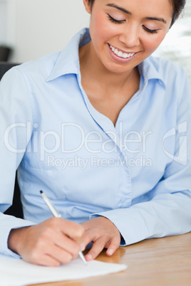 Frontal view of a good looking woman writing on a sheet of paper